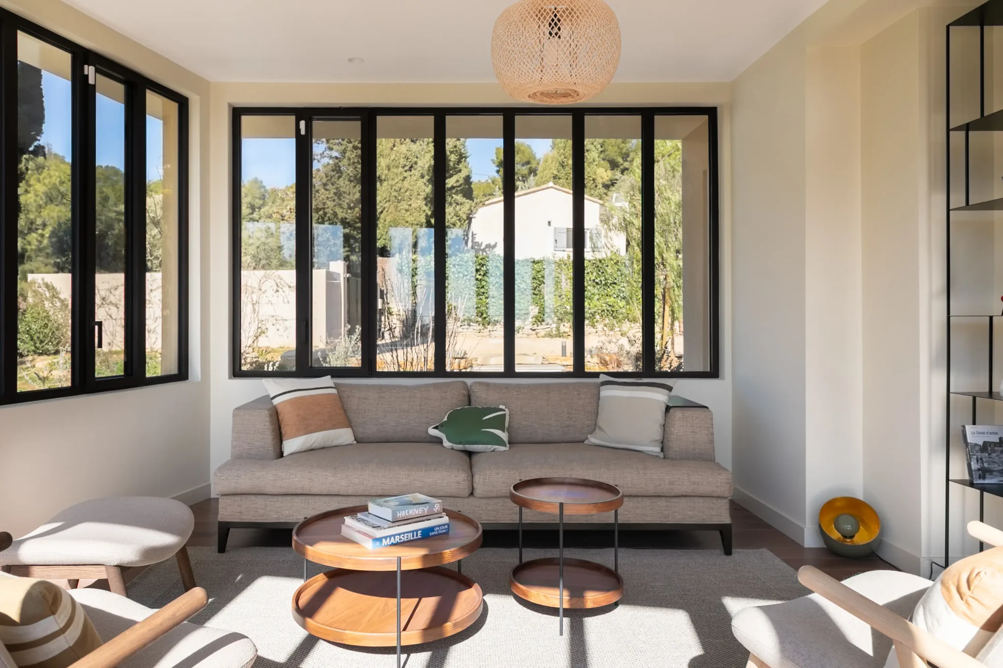 extension de maison véranda avec verrière style atelier bibliothèque métal AMPM canapé et fauteuils Bolia sol en parquet foncé