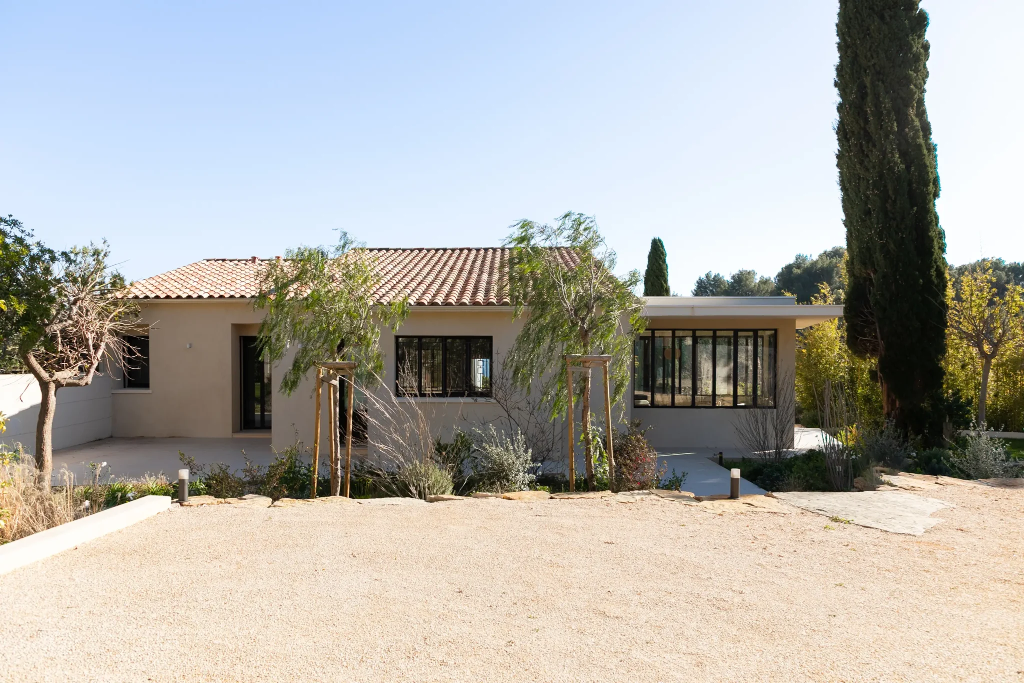 rénovation de maison provençale extension de maison véranda avec verrière style atelier et débord de toiture jardin paysager façade de la maison surélévation de la toiture