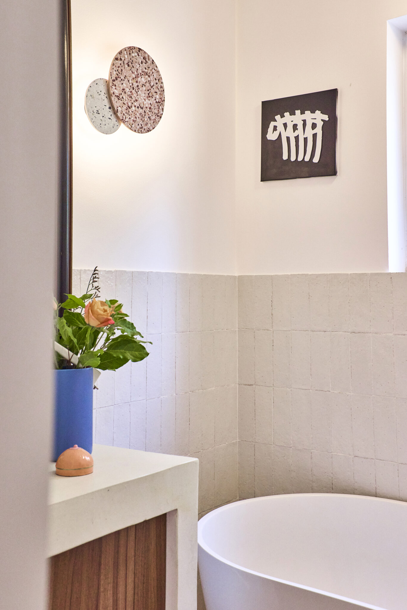 rénovation de salle de bains avec baignoire ilot carrelage mural en zellige teinte nude meuble vasque en béton ciré sur mesure applique murale en terrazzo rose