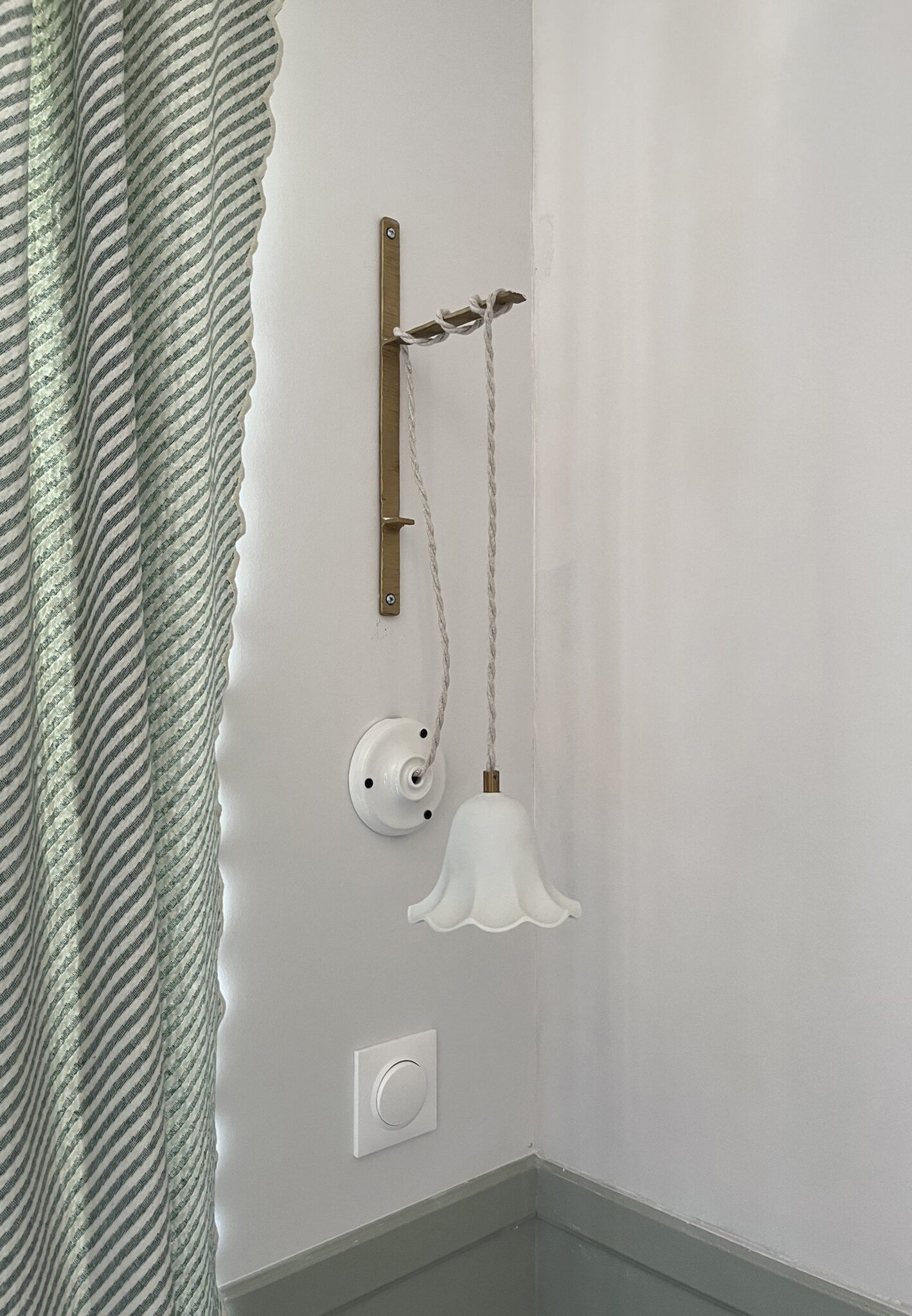 décoration de chambre de petit garçon dans les tons verts et blanc avec rideaux rayés vert et suspension lumineuse de la marque Enamoura boiserie murale